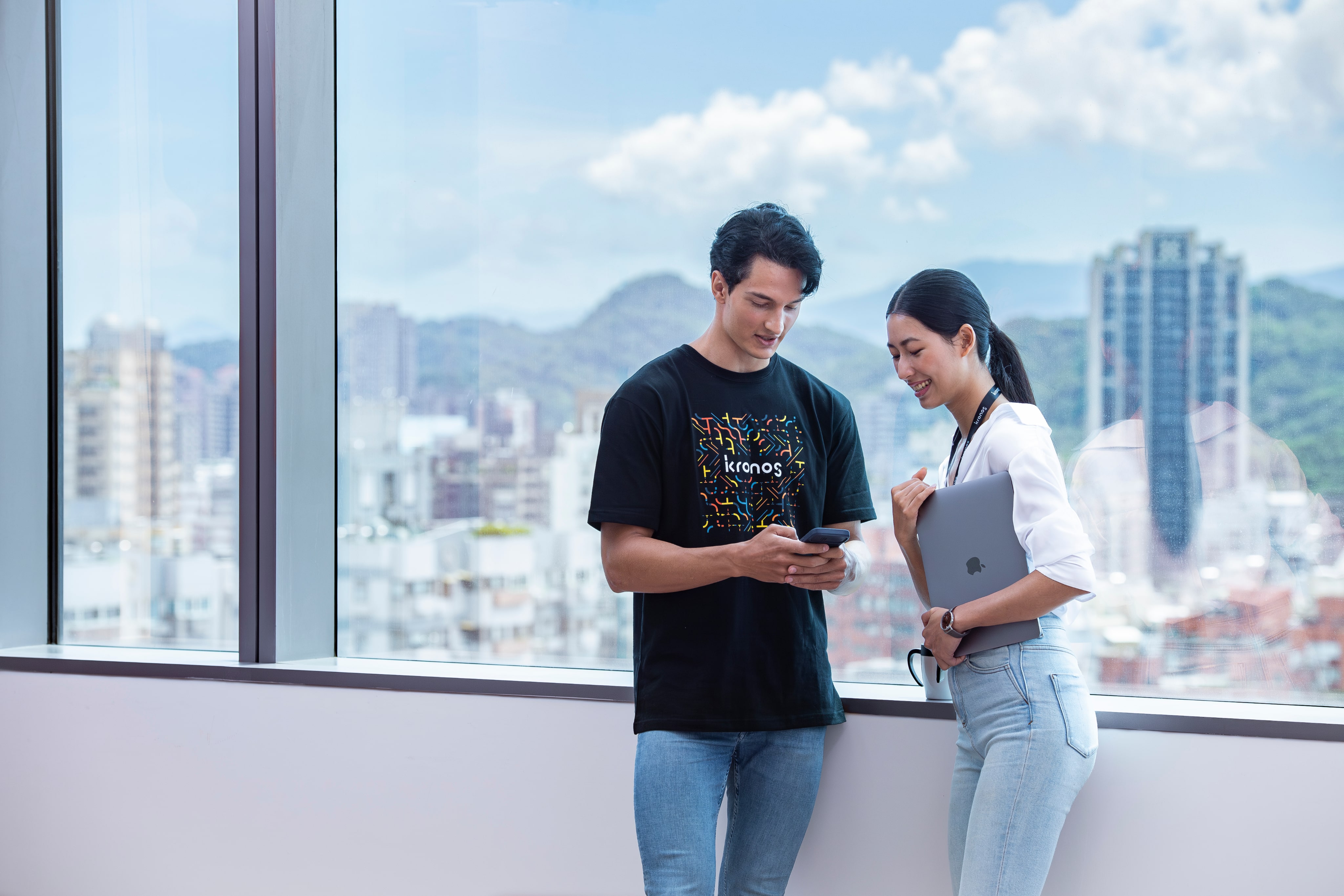 Two kronos employees chatting in front of large window